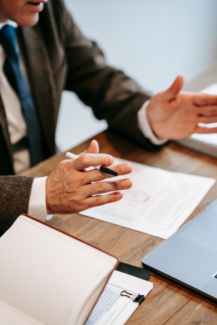 who-we-are Professional discussing documents over a wooden table in an office setting.
